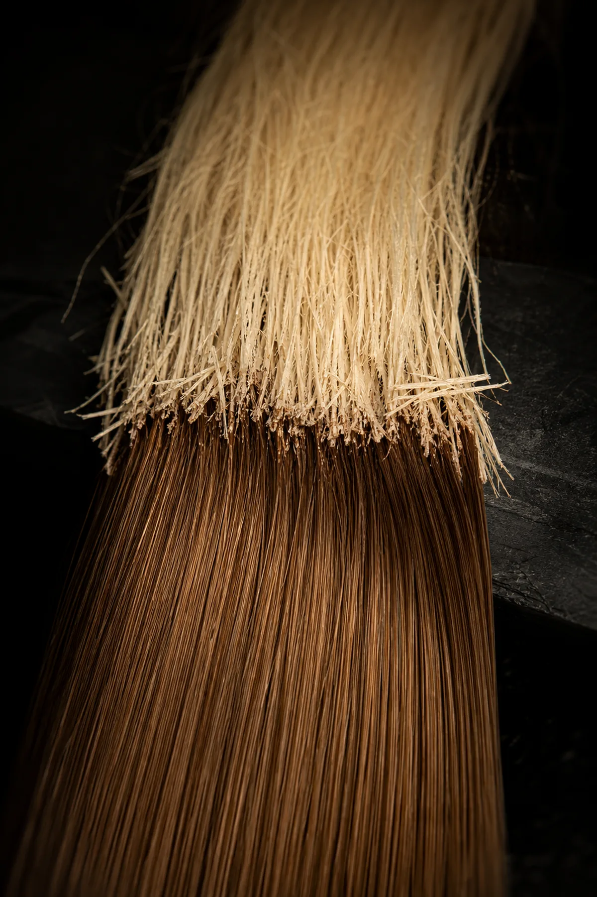 Mechas loiras separadas em papel alumínio sobre cabelo escuro em salão